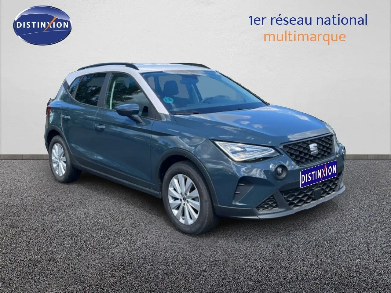 SEAT Arona bleu Fjord avec toit blanc, vue 3/4 avant droit, mettant en valeur ses lignes modernes et ses jantes argentées.