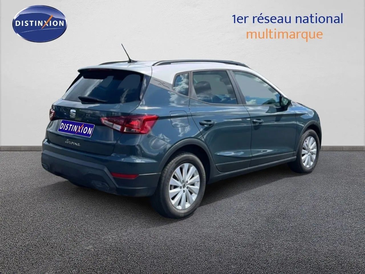 Vue 3/4 arrière droite d'un SEAT Arona bleu Fjord avec toit blanc, jantes 16 pouces et vitres teintées.