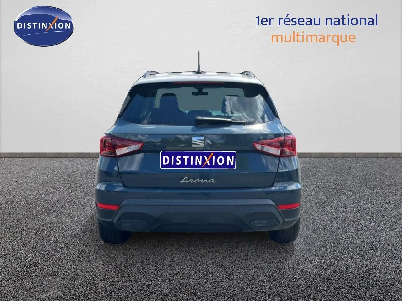 Vue arrière d’un SEAT Arona bleu Fjord avec toit blanc, version Style Special Edition 2025, sur fond gris neutre.