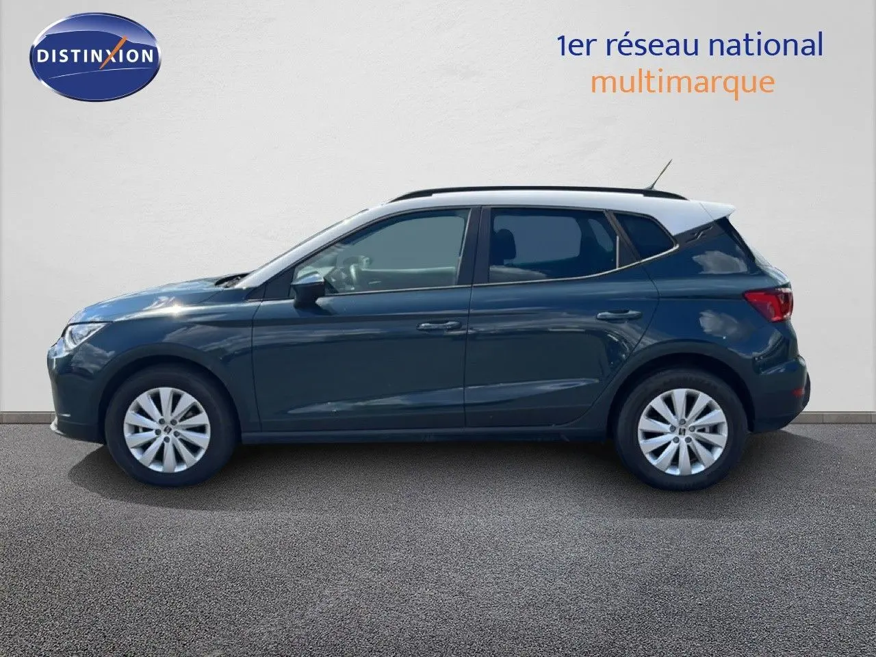 Profil côté gauche d'un SEAT Arona bleu Fjord avec toit blanc, roues alliage et lignes épurées, sur fond neutre.