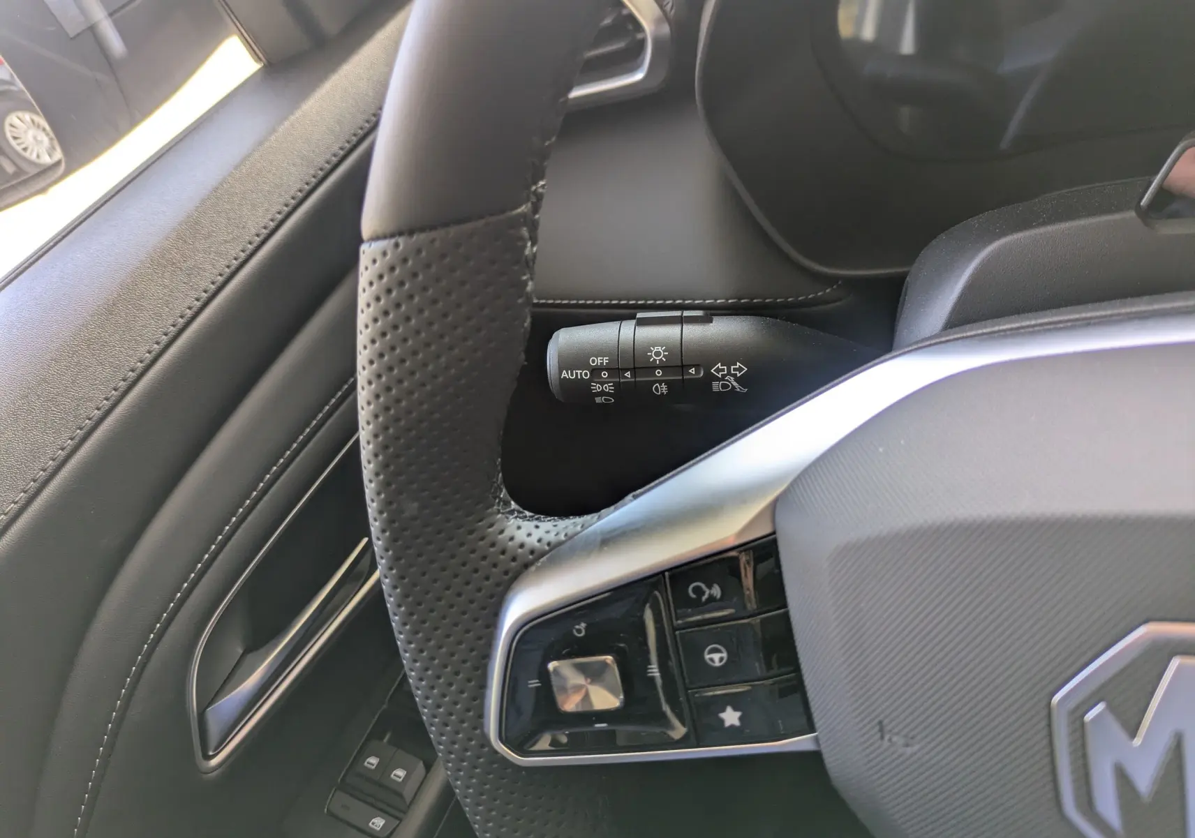 Vue intérieure côté conducteur du MG ZS 2026 en Candem Grey, sièges en similicuir noir perforé et volant cuir chauffant.