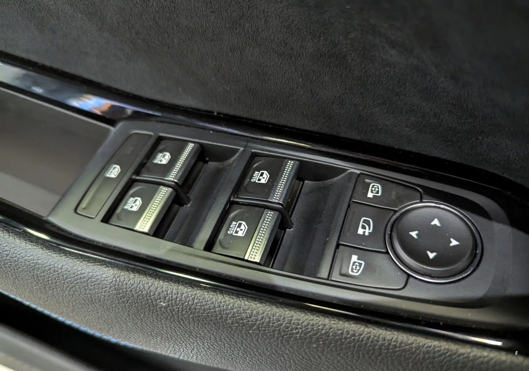 Gros plan sur les commandes des vitres et rétroviseurs côté conducteur du Renault Austral blanc nacré 2023.