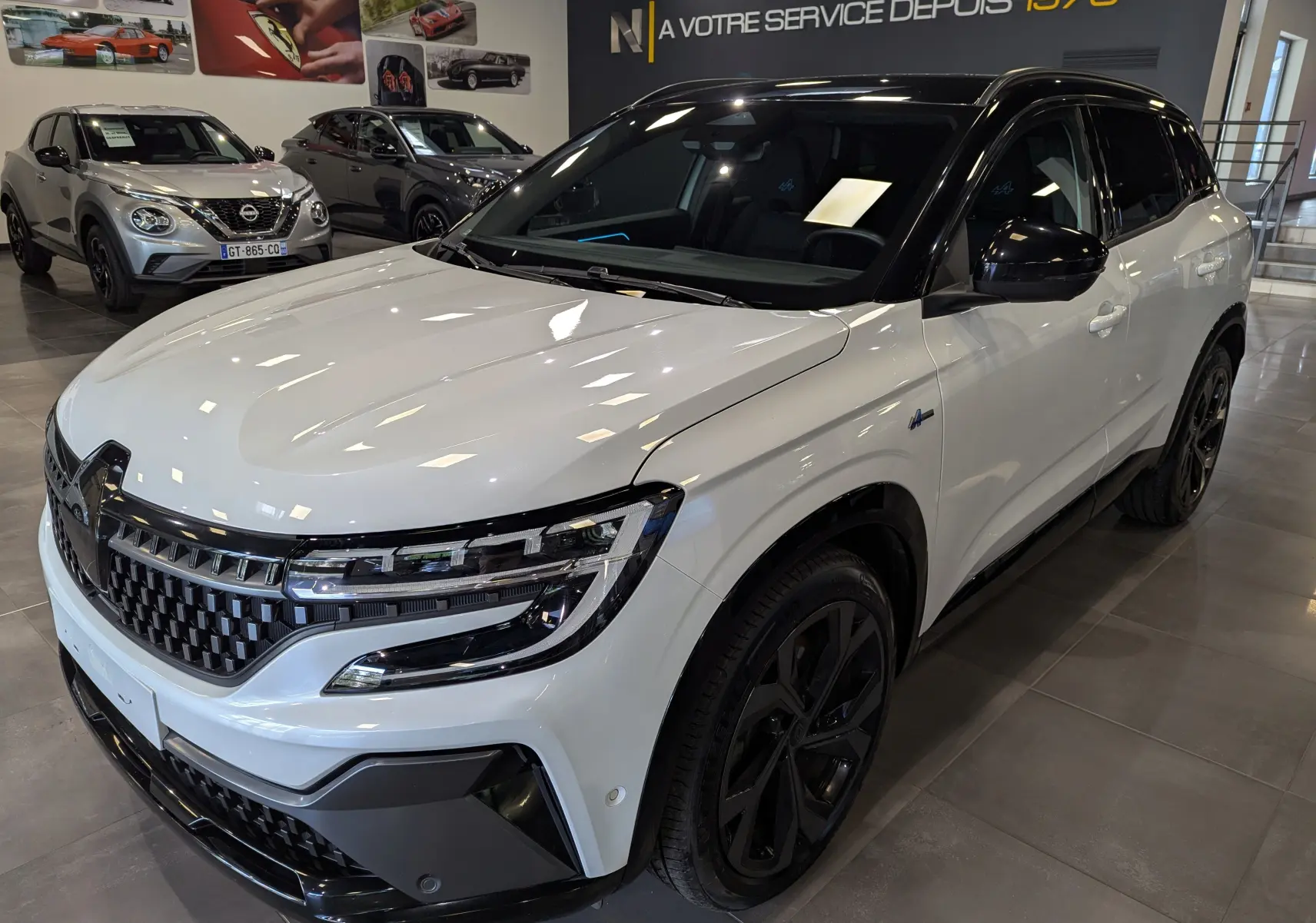 Renault Austral E-Tech blanc nacré avec toit noir, vue 3/4 avant droit en showroom lumineux.
