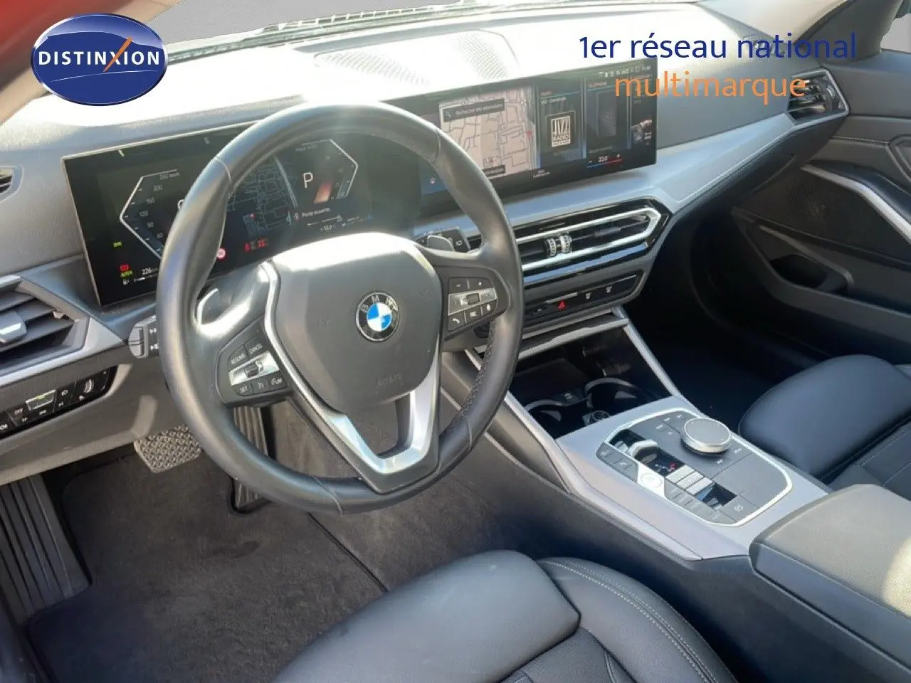 Vue intérieure de la BMW Série 3 Touring F31 316d 2022, tableau de bord et volant cuir noir avec écran digital large.