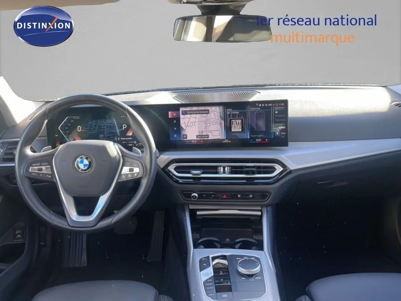 Vue intérieure avant de la BMW Série 3 Touring F31 noire, montrant le volant multifonction et l'écran tactile large du tableau de bord.
