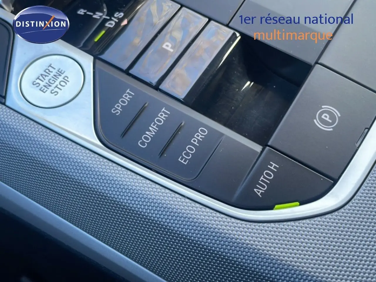 Gros plan sur la console centrale noire de la BMW Série 3 Touring F31, avec boutons de modes de conduite et démarrage.
