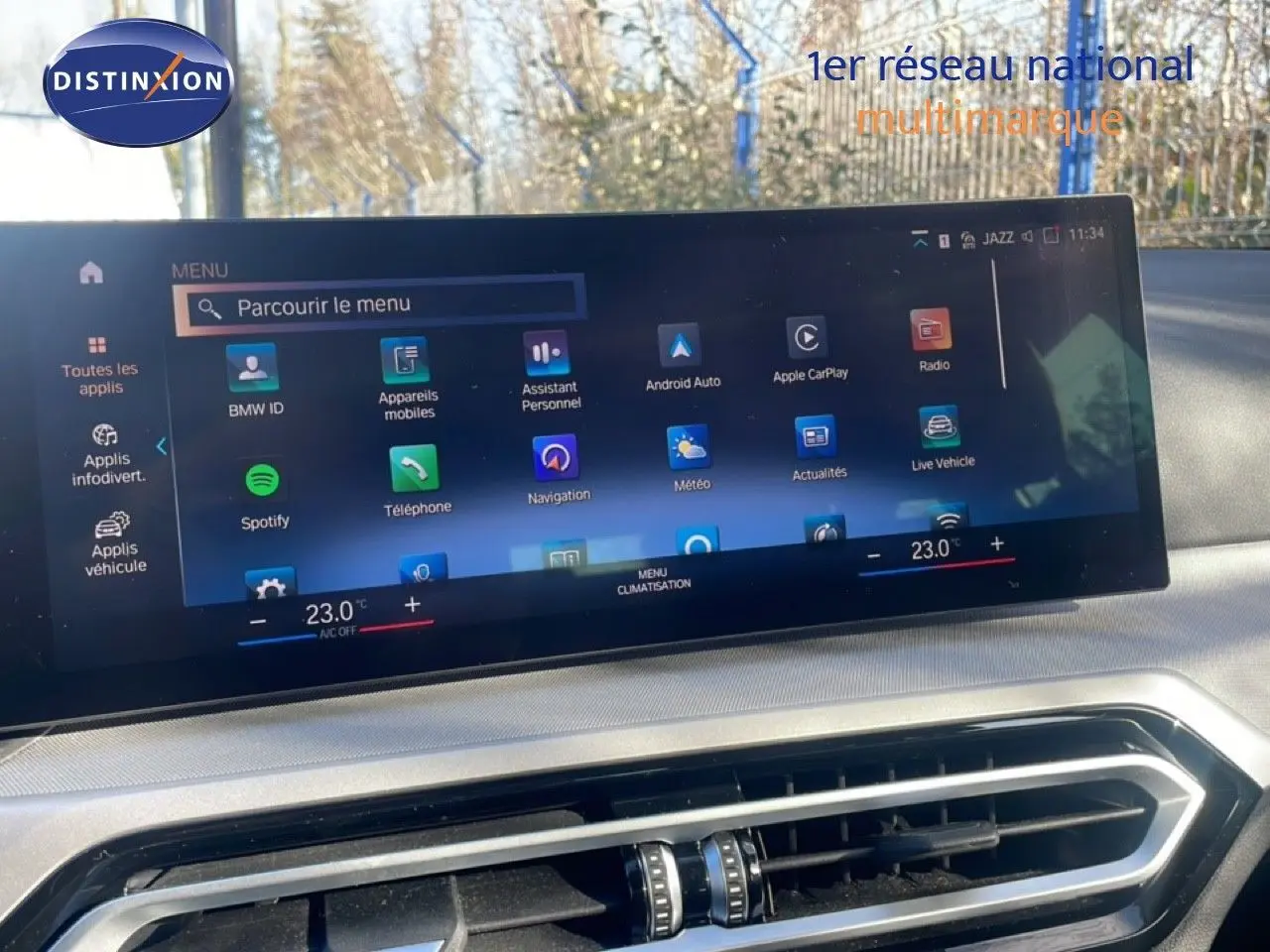Écran tactile central affichant le menu multimédia et climatisation dans l'habitacle d'une BMW Série 3 Touring noire.