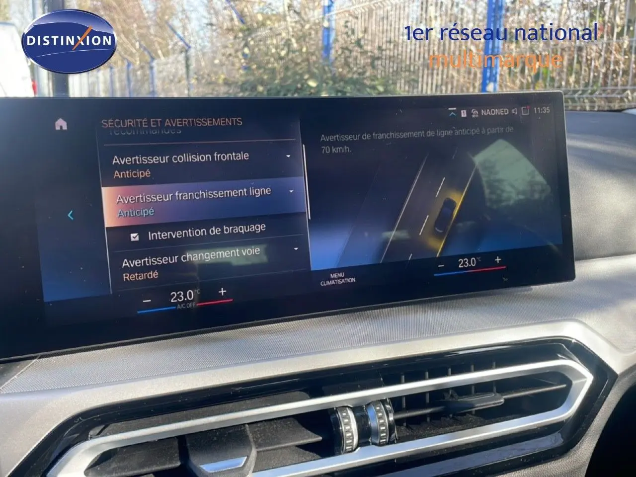 Écran central tactile de la BMW Série 3 Touring F31 noir, affichant les alertes de sécurité et la climatisation à 23°C.