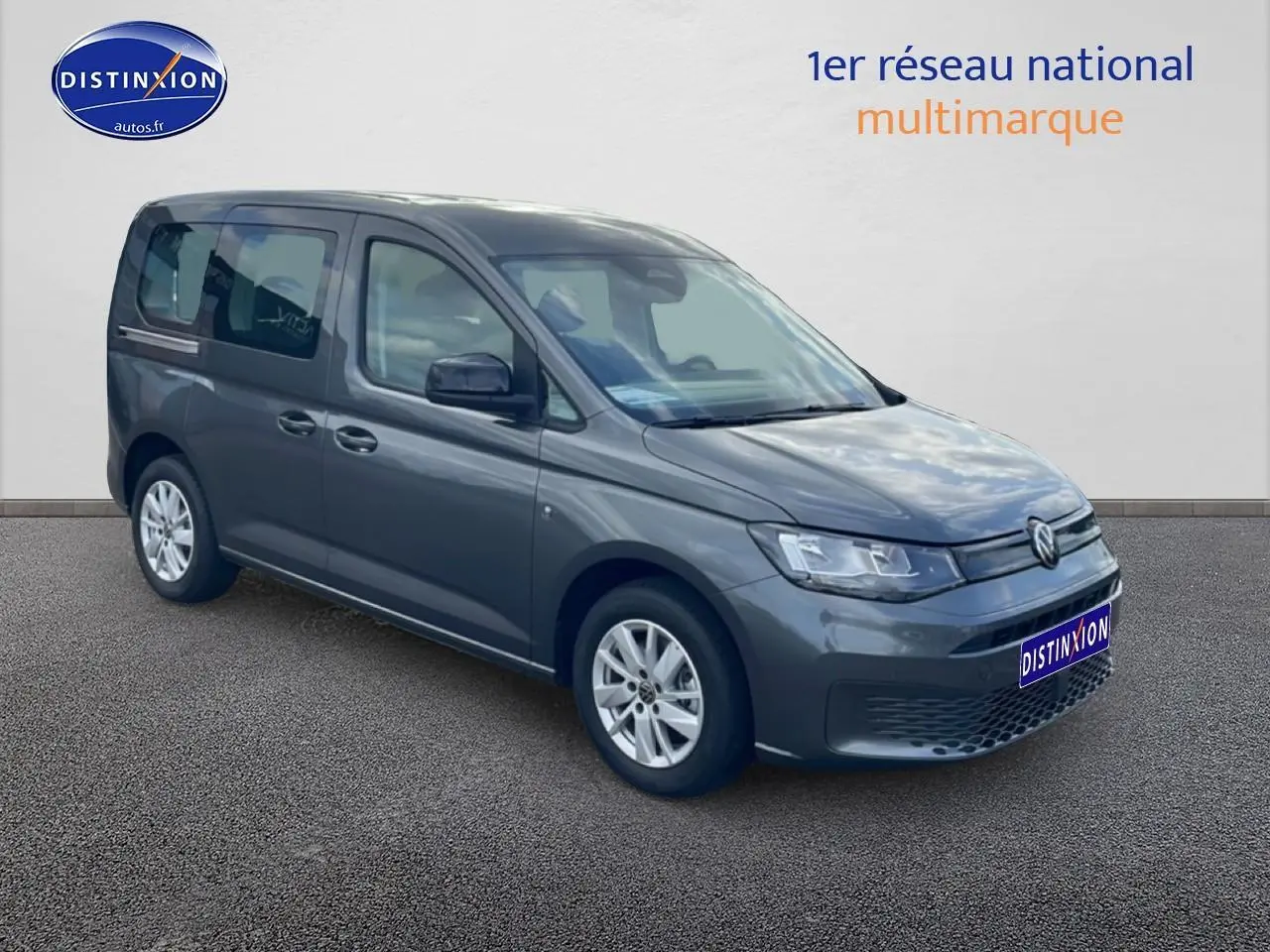 Volkswagen Caddy gris indien en 3/4 avant droit, avec jantes alliage et vitres teintées arrière.