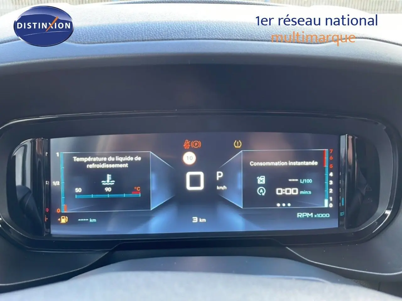 Affichage numérique du tableau de bord du Citroën Berlingo blanc, montrant la température moteur et la consommation instantanée.