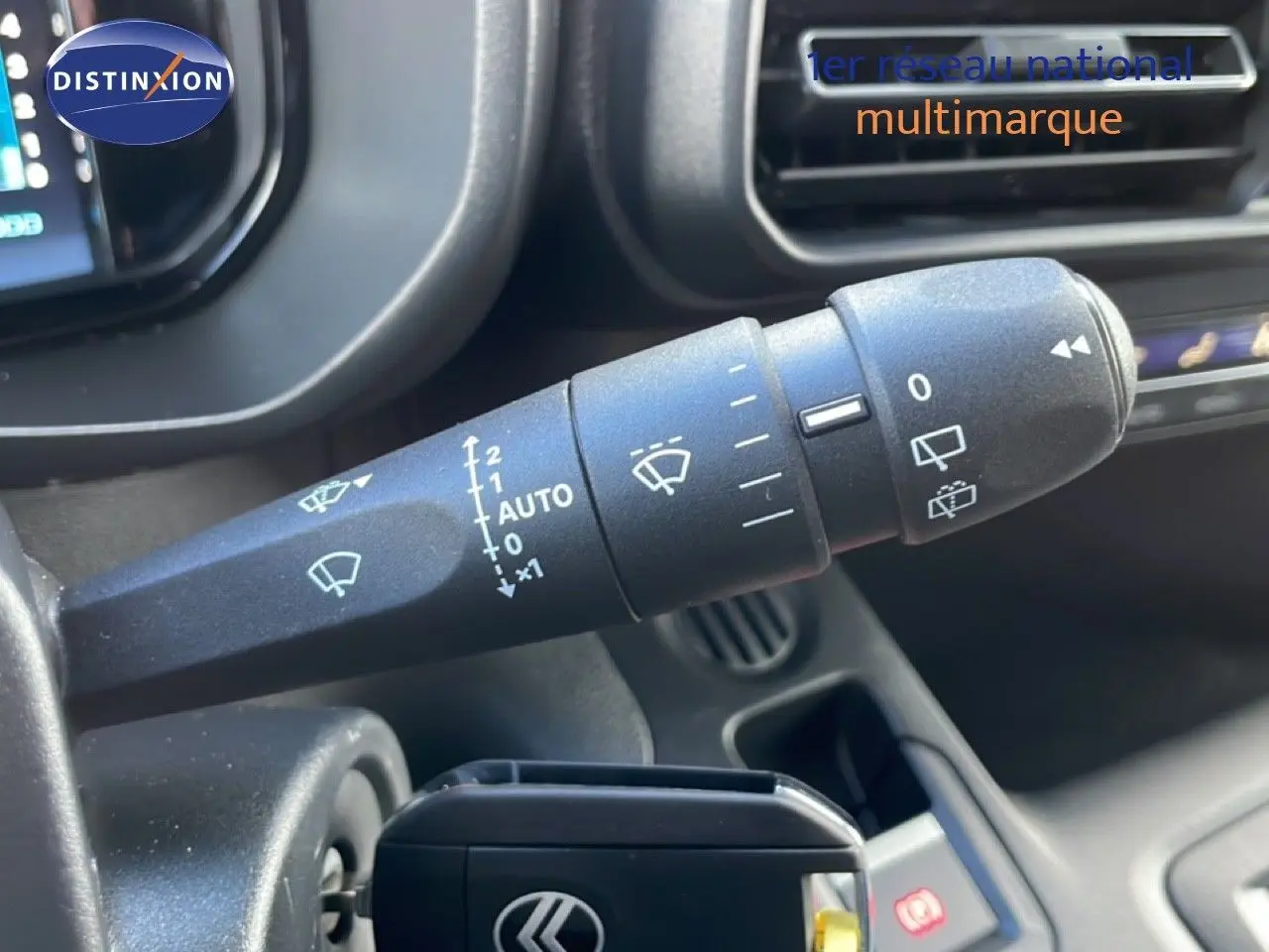 Gros plan sur la commande d'essuie-glace côté gauche du tableau de bord d'un Citroën Berlingo blanc glacier.