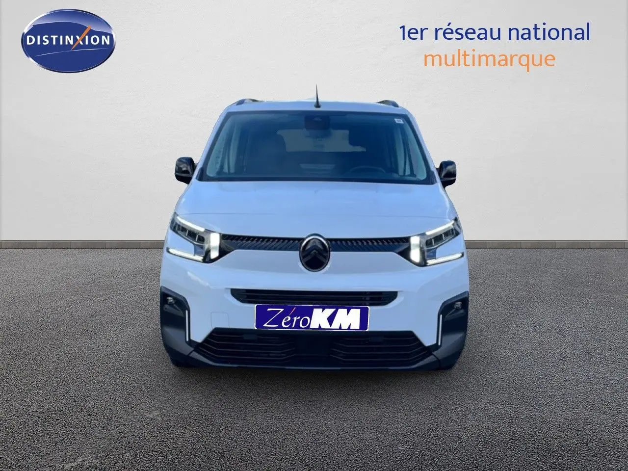 Vue frontale d'un Citroën Berlingo Multispace blanc glacier avec feux LED allumés sur fond neutre.