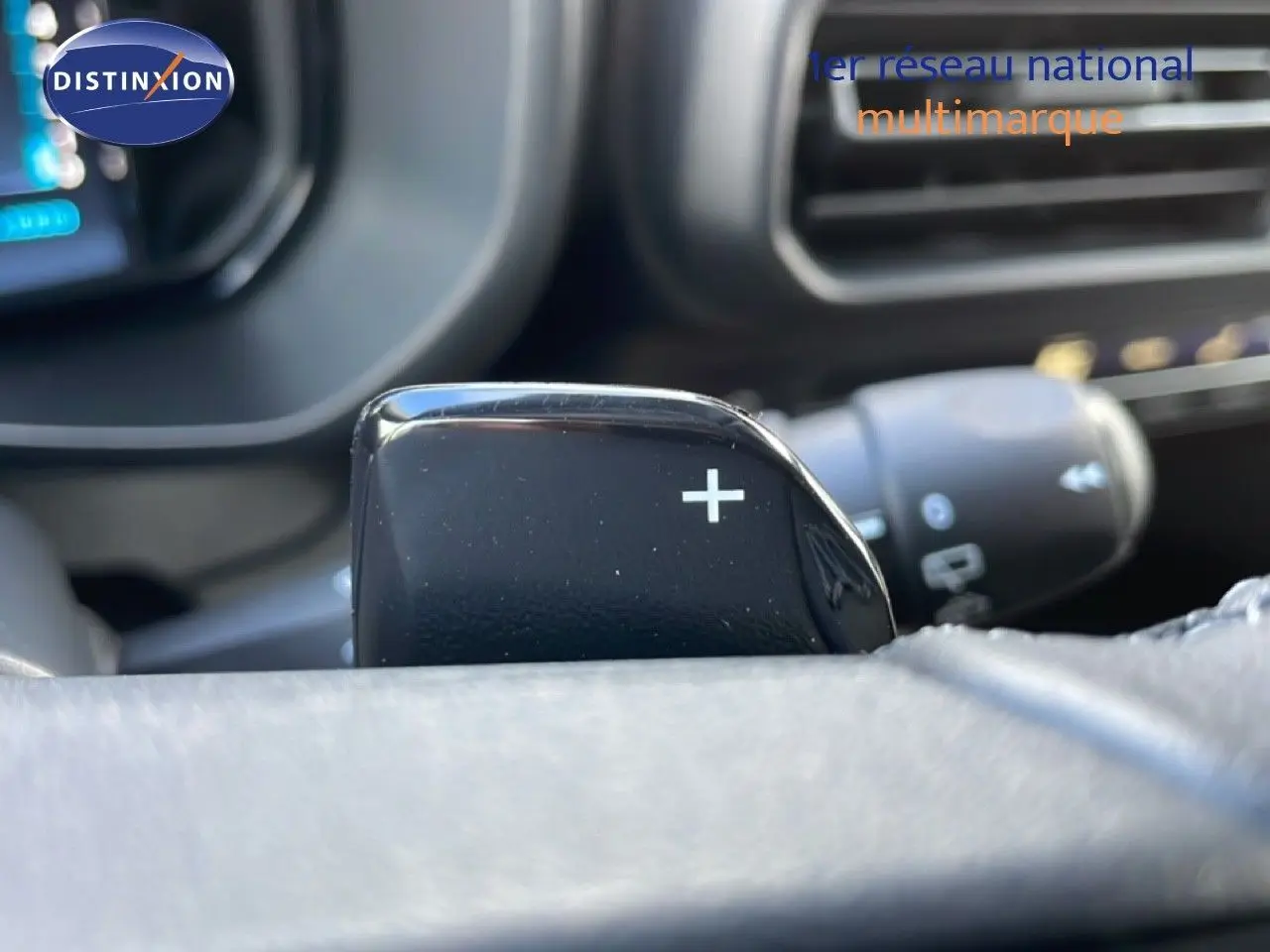 Gros plan sur la palette de changement de vitesse "+" côté droit du volant dans un Citroën Berlingo blanc glacier.