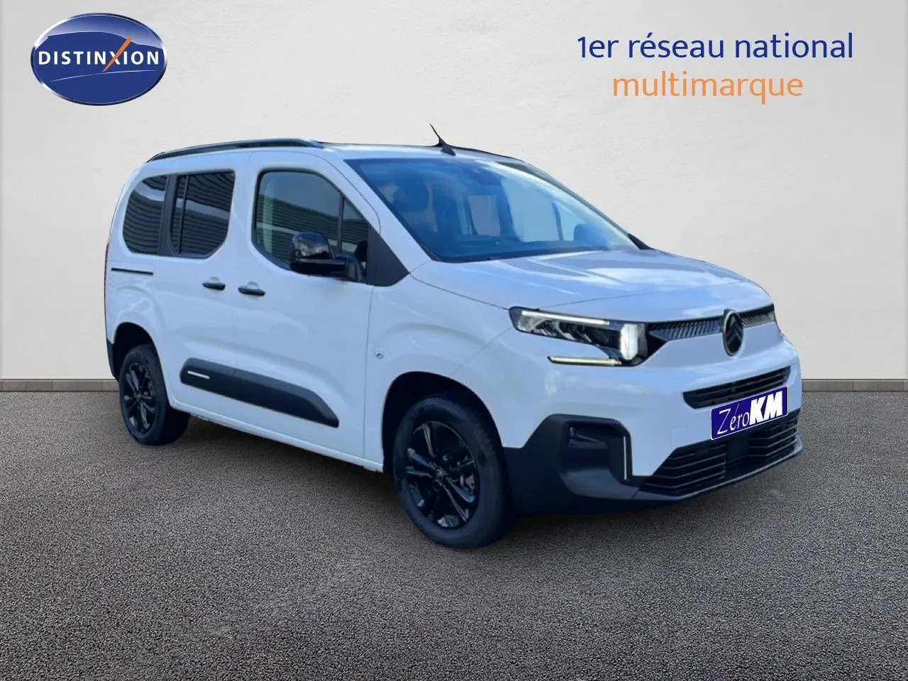 Vue 3/4 avant droite d'un Citroën Berlingo blanc glacier avec jantes noires et protections latérales noires.