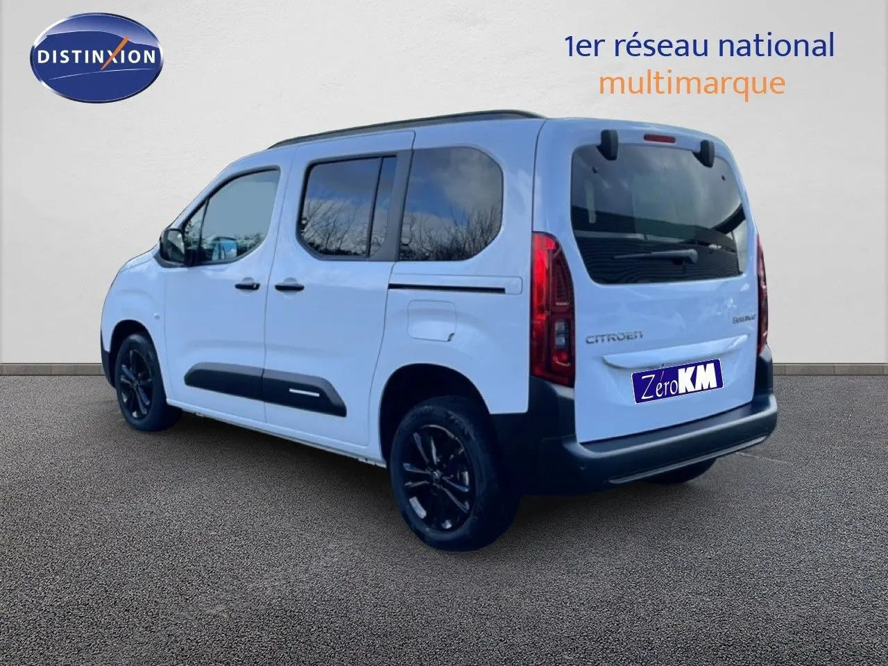 Vue 3/4 arrière droite d'un Citroën Berlingo Multispace blanc glacier avec jantes noires et vitres teintées.