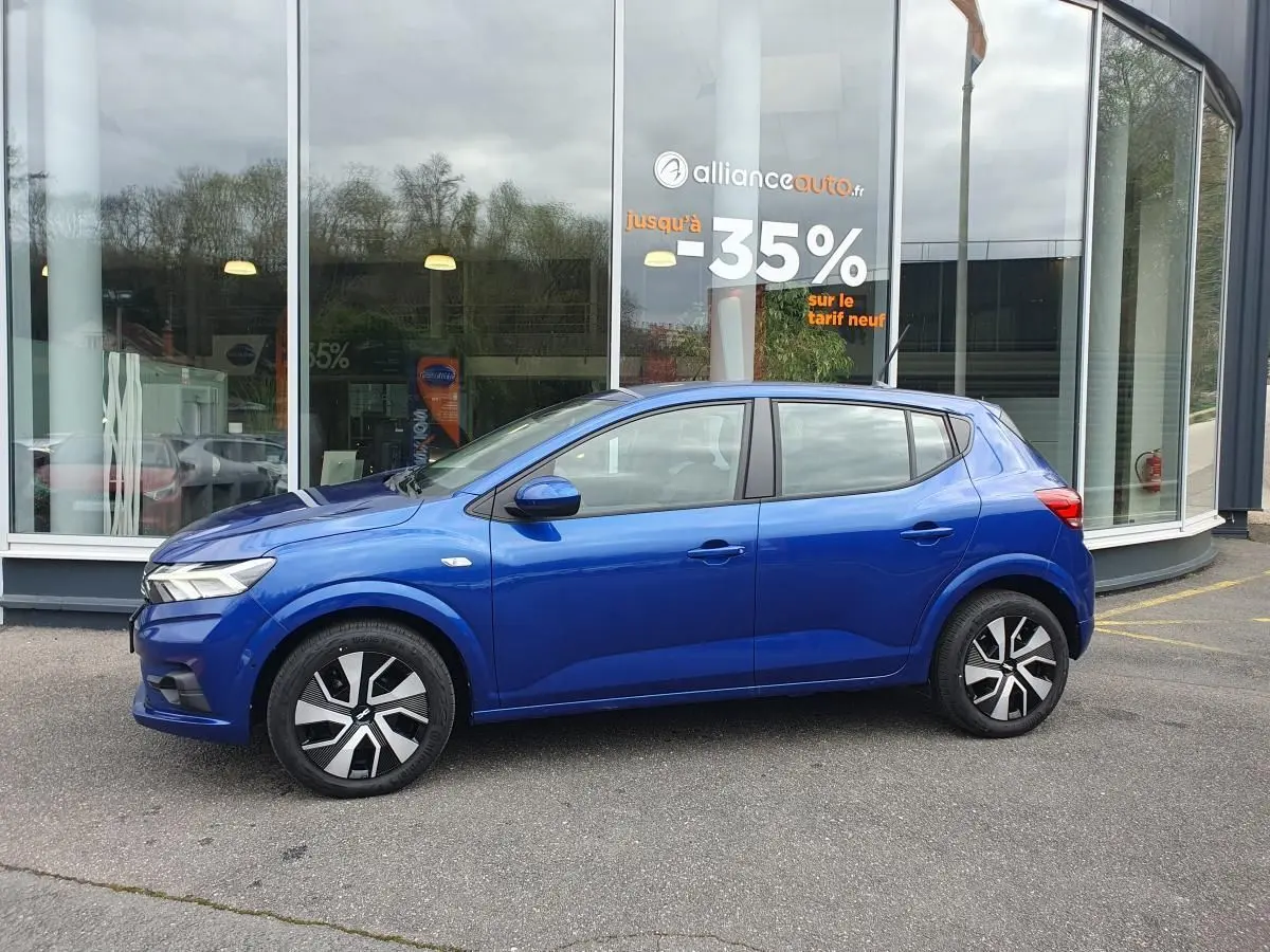 Profil côté gauche de la Dacia Sandero 2025 bleu Iron avec enjoliveurs noirs et signature lumineuse LED visible.