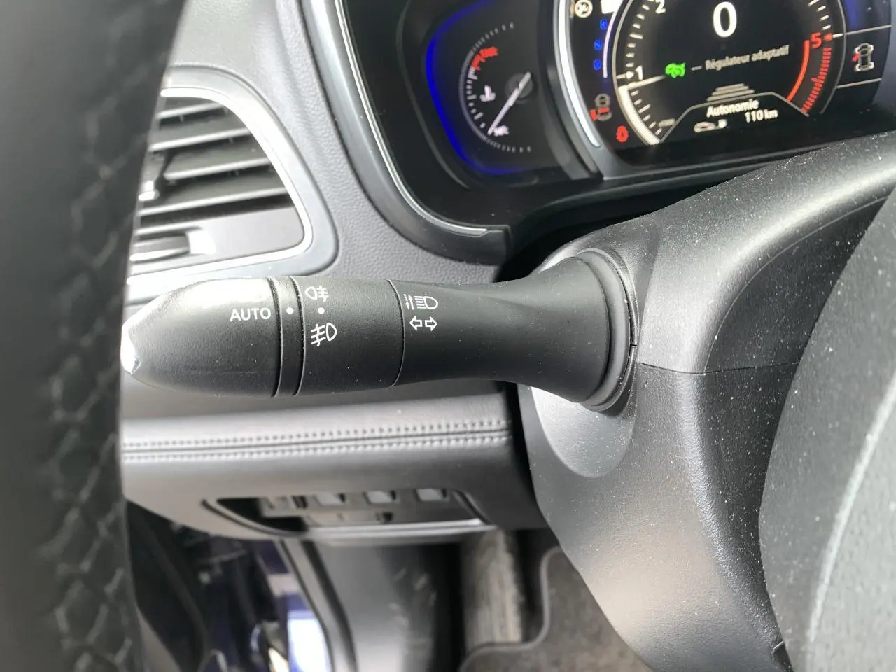 Gros plan sur la manette de commande des phares et clignotants côté gauche du tableau de bord du Renault Koleos bleu foncé 2019.