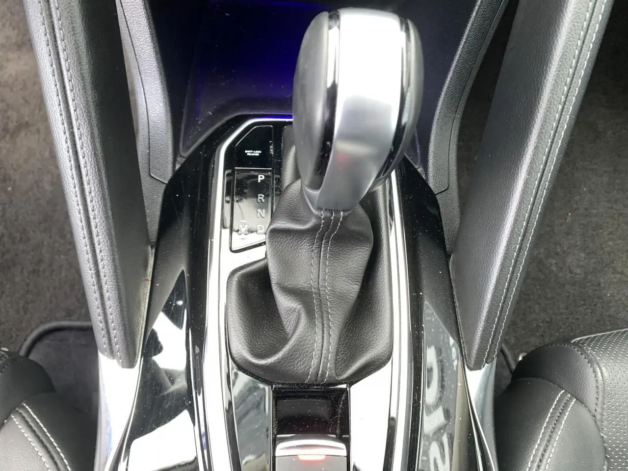 Gros plan sur la console centrale du Renault Koleos 2019, levier de vitesses automatique en cuir noir.