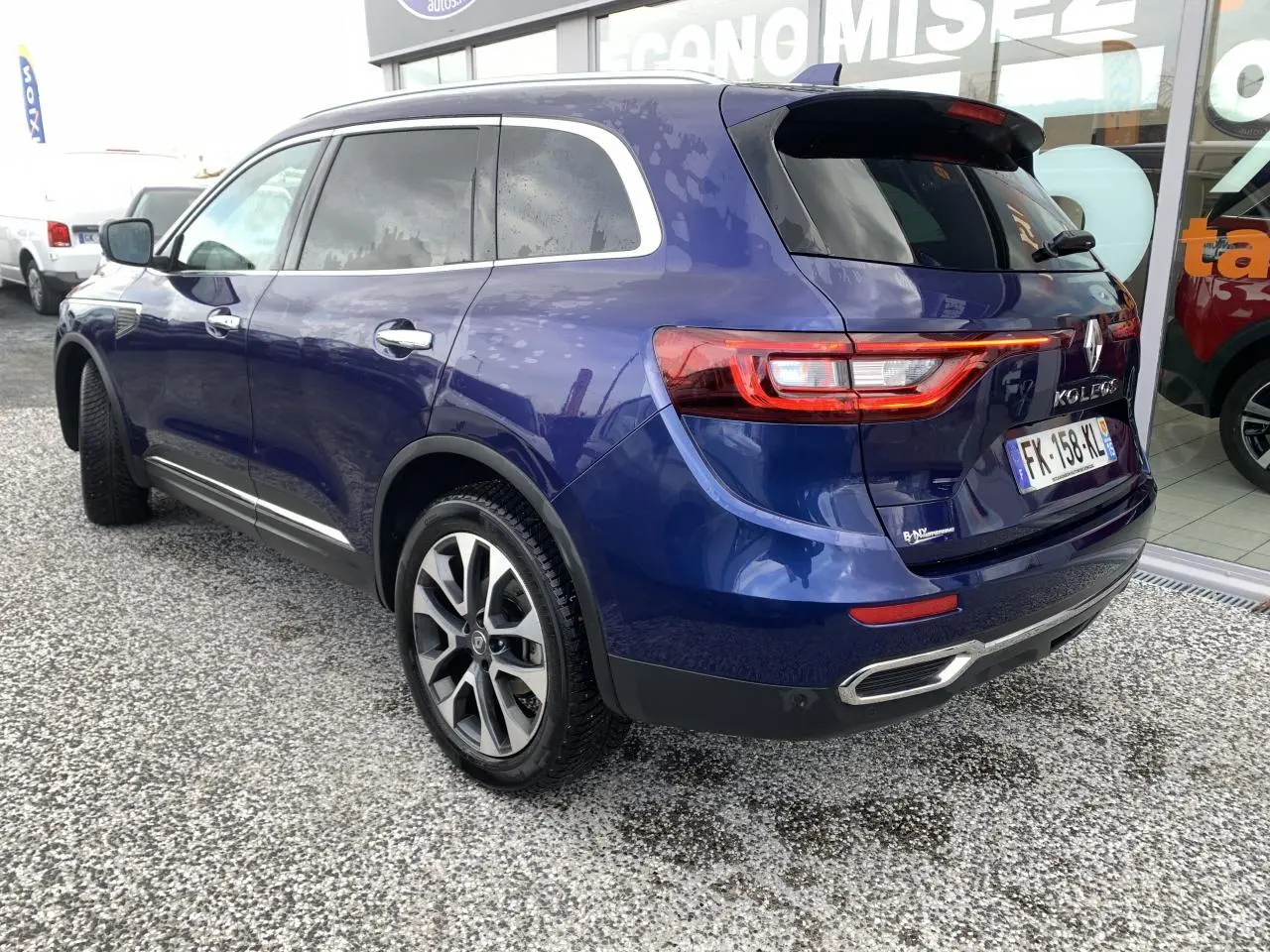 Vue 3/4 arrière droite du Renault Koleos bleu foncé avec feux LED et jantes alliage 19 pouces visibles.