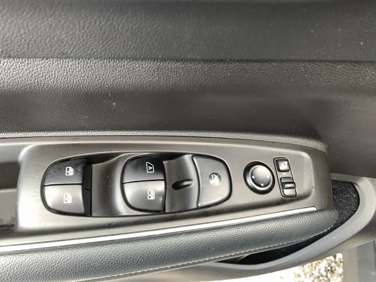Gros plan sur les commandes de lève-vitres et rétroviseurs côté gauche du Renault Koleos 2019 bleu foncé.
