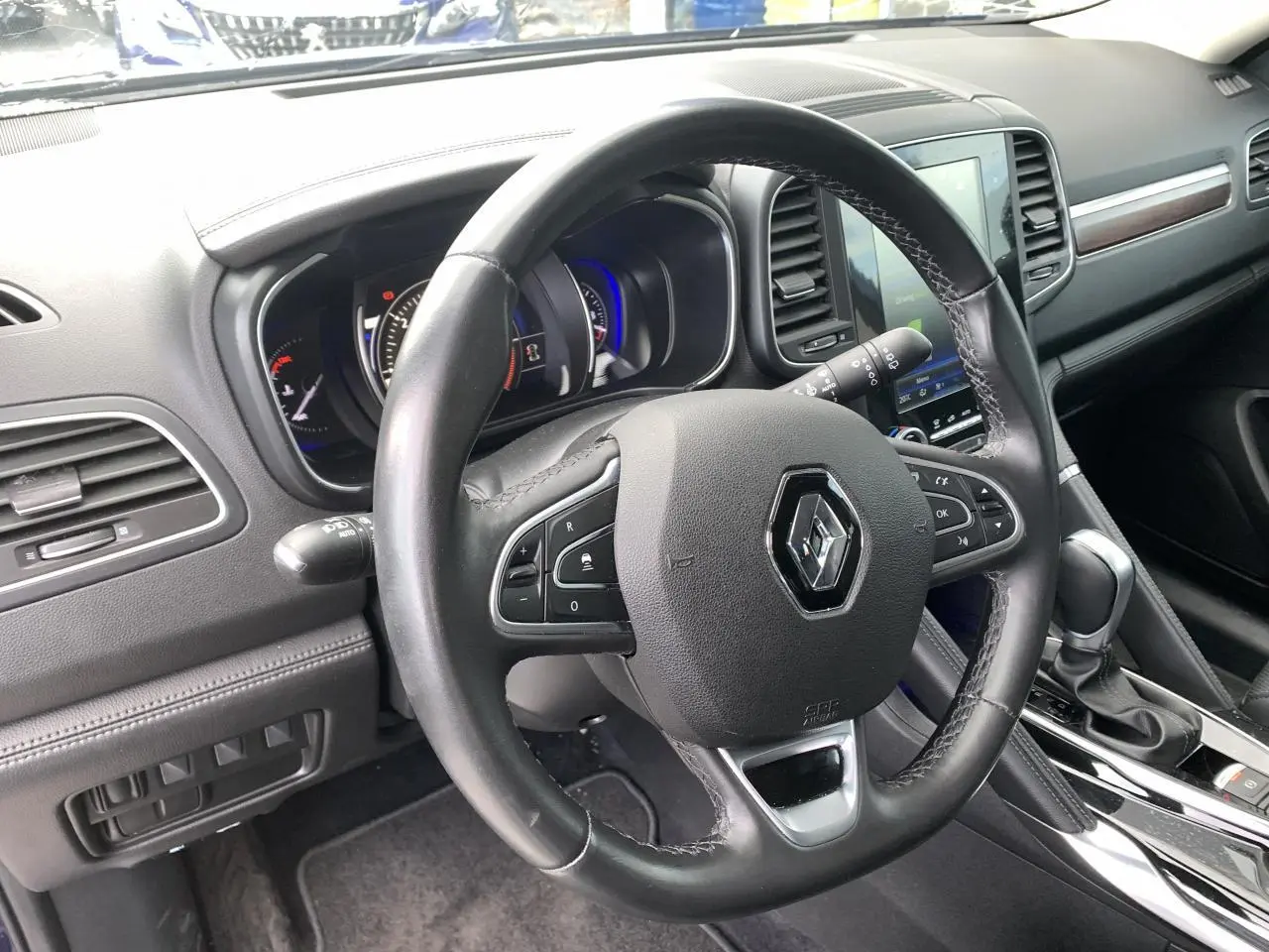 Vue intérieure du volant cuir noir du Renault Koleos 2019 avec tableau de bord et console centrale en noir brillant.