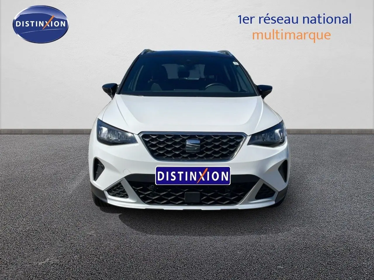 Vue frontale d'un SEAT Arona blanc Nevada avec toit noir, mettant en valeur sa calandre et ses phares LED.