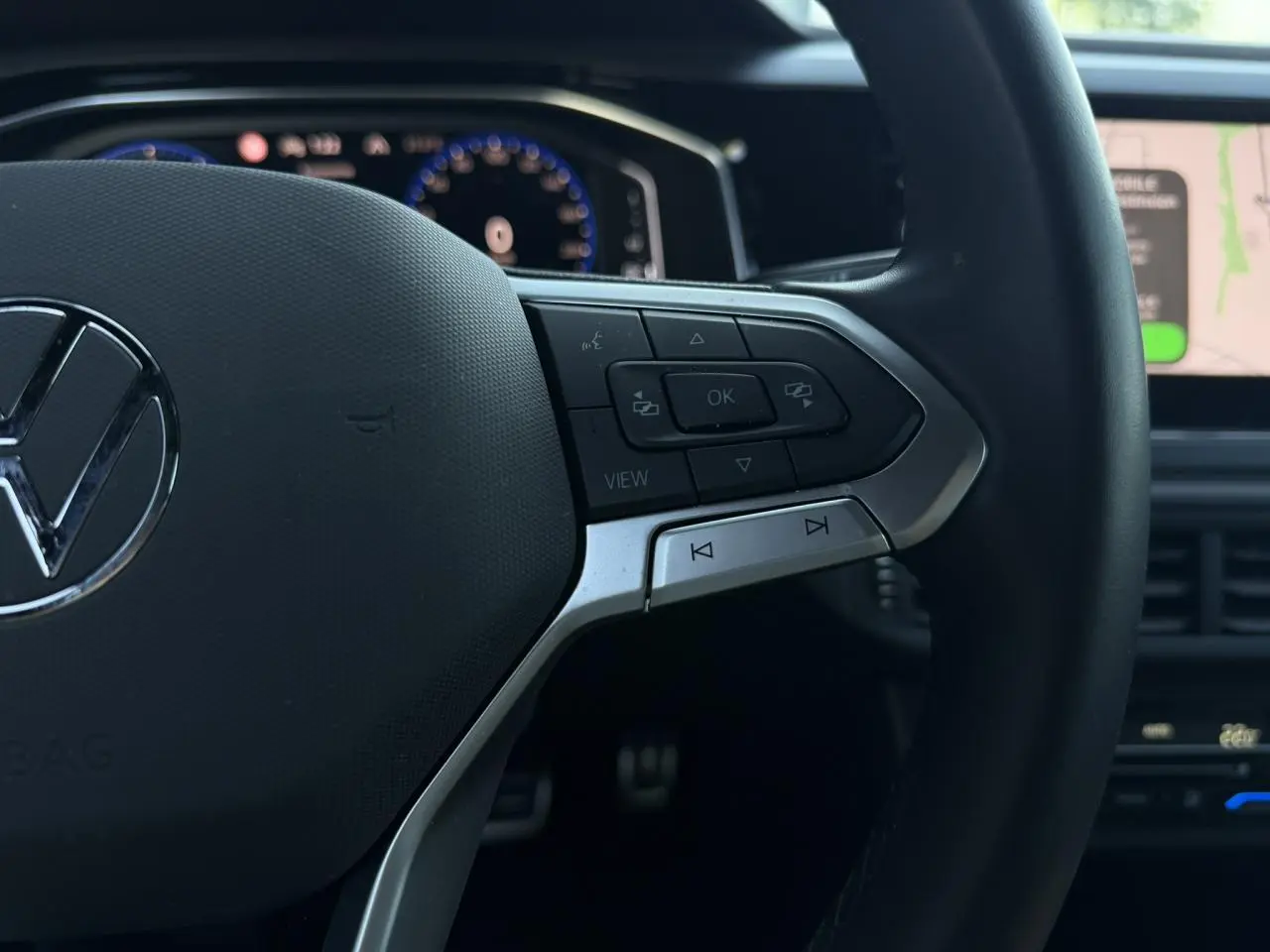 Gros plan sur le volant multifonctions cuir du Volkswagen Taigo TSI 116 DSG R-Line, boutons de commande à droite visibles.