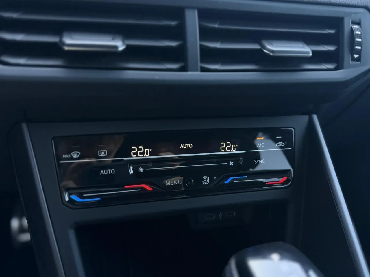 Vue rapprochée de la console centrale du Volkswagen Taigo gris, affichant la climatisation automatique bi-zone à 22°C.