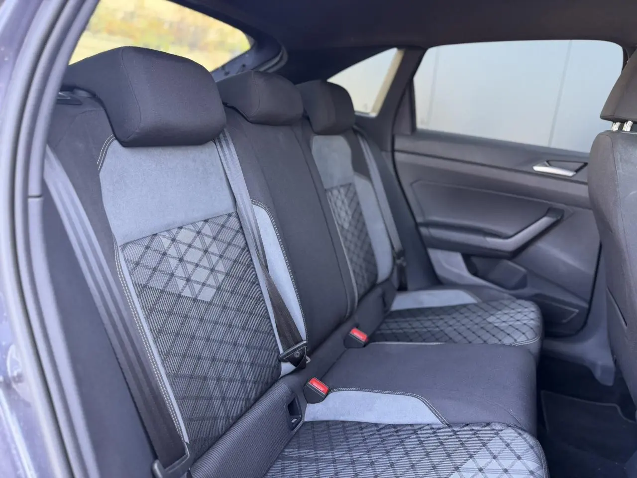 Vue intérieure côté gauche des sièges arrière en tissu noir et gris avec motifs géométriques du Volkswagen Taigo TSI 116 DSG R-Line 2025.