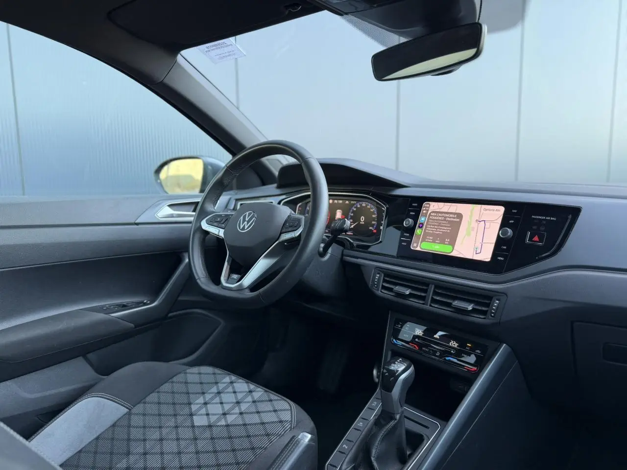 Vue intérieure côté conducteur du Volkswagen Taigo 2025, tableau de bord moderne avec écran tactile et volant multifonctions cuir.