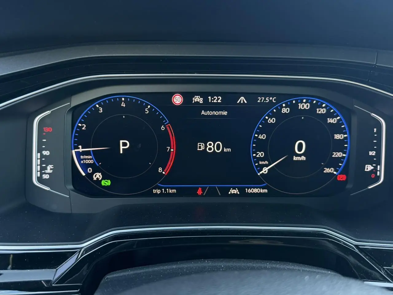 Vue rapprochée du tableau de bord numérique du Volkswagen Taigo gris, affichant la vitesse à 0 km/h et l'autonomie à 80 km.