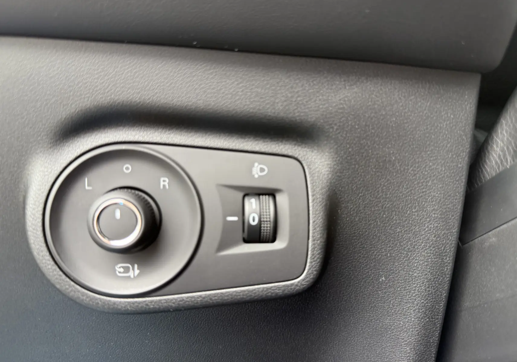 Gros plan sur les commandes de réglage des rétroviseurs et de l'éclairage du tableau de bord d'un MG Motor ZS 2025.