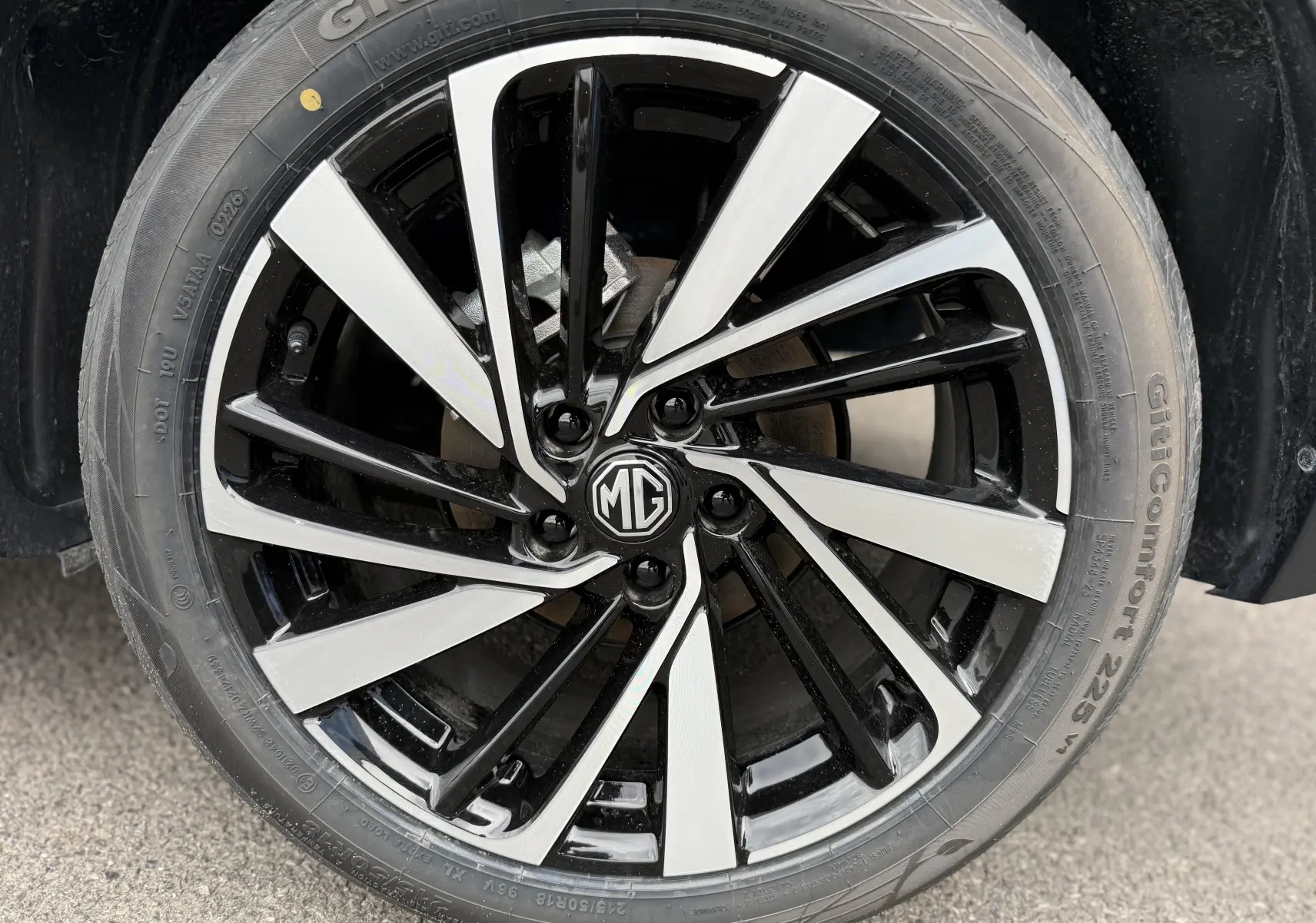 Gros plan sur la jante bicolore noire et argentée d’un MG ZS 1.5L HYBRID+ 2025, avec logo MG au centre.