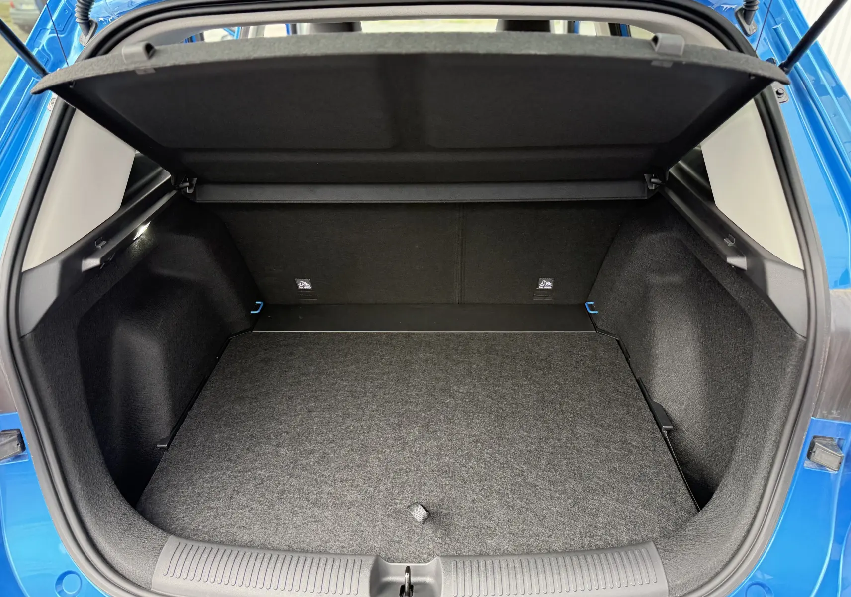 Coffre ouvert vu de l'arrière d'un MG MOTOR ZS 1.5L HYBRID+ 197CH Luxury en bleu Como Metal, intérieur noir.
