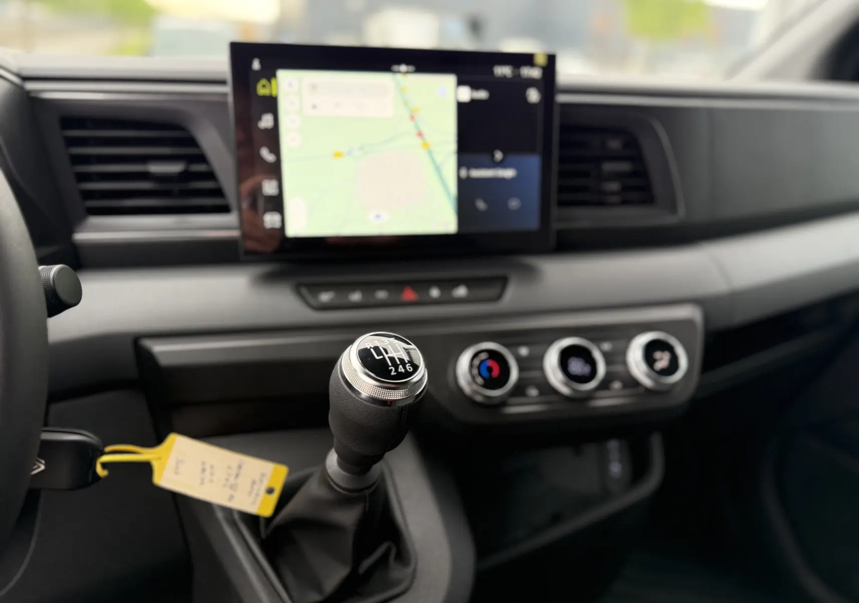 Gros plan sur le levier de vitesses manuel du Renault Master 2024 avec écran tactile et commandes de climatisation visibles.