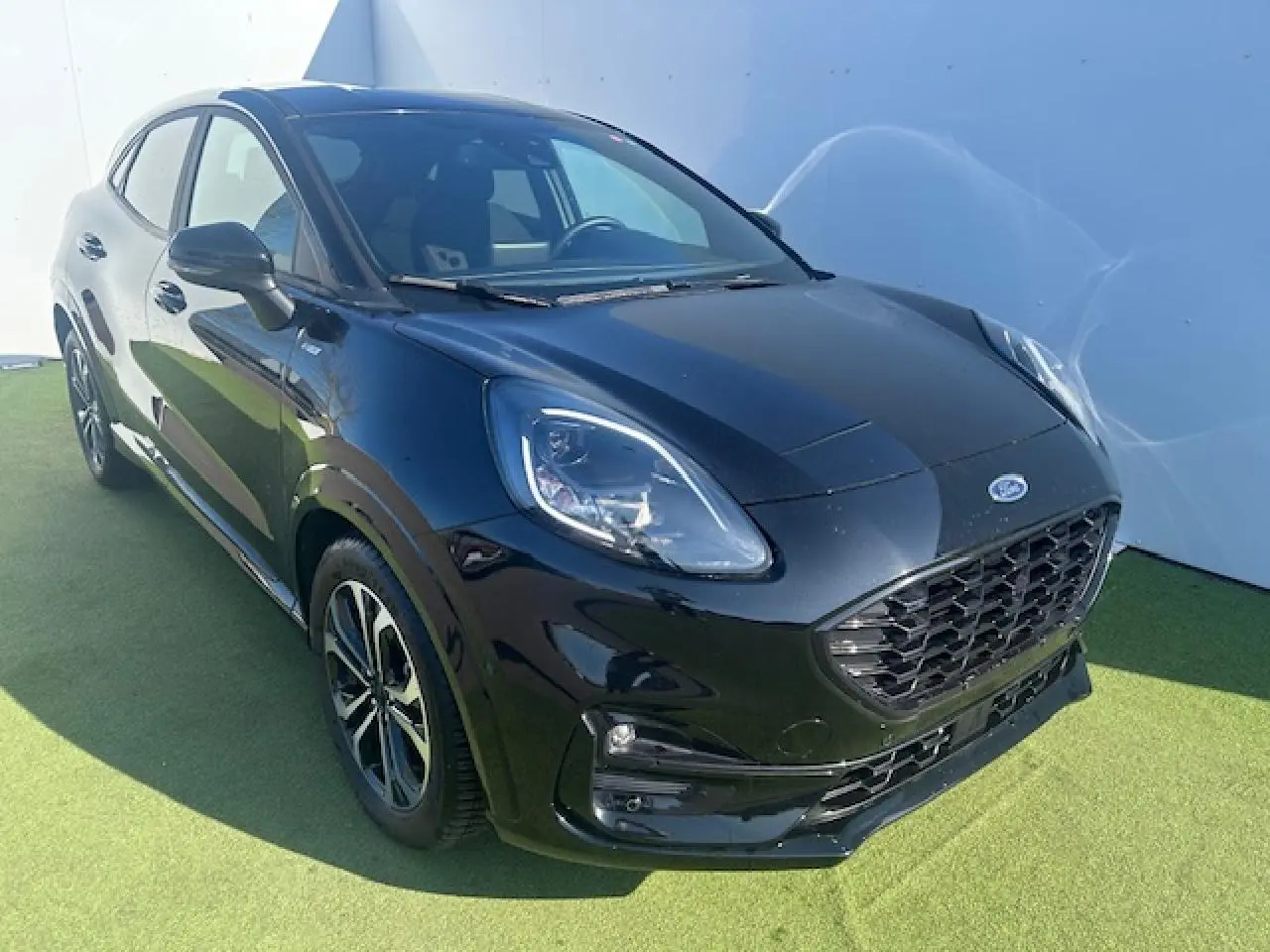 Ford Puma noir Agate en vue 3/4 avant droit, avec calandre large et jantes alliage 17 pouces visibles.