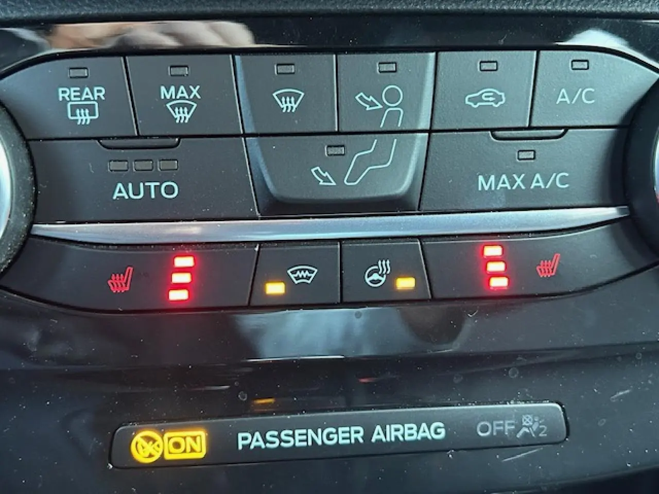 Gros plan sur la console centrale du Ford Puma noir Agate, affichant les commandes de climatisation et sièges chauffants.