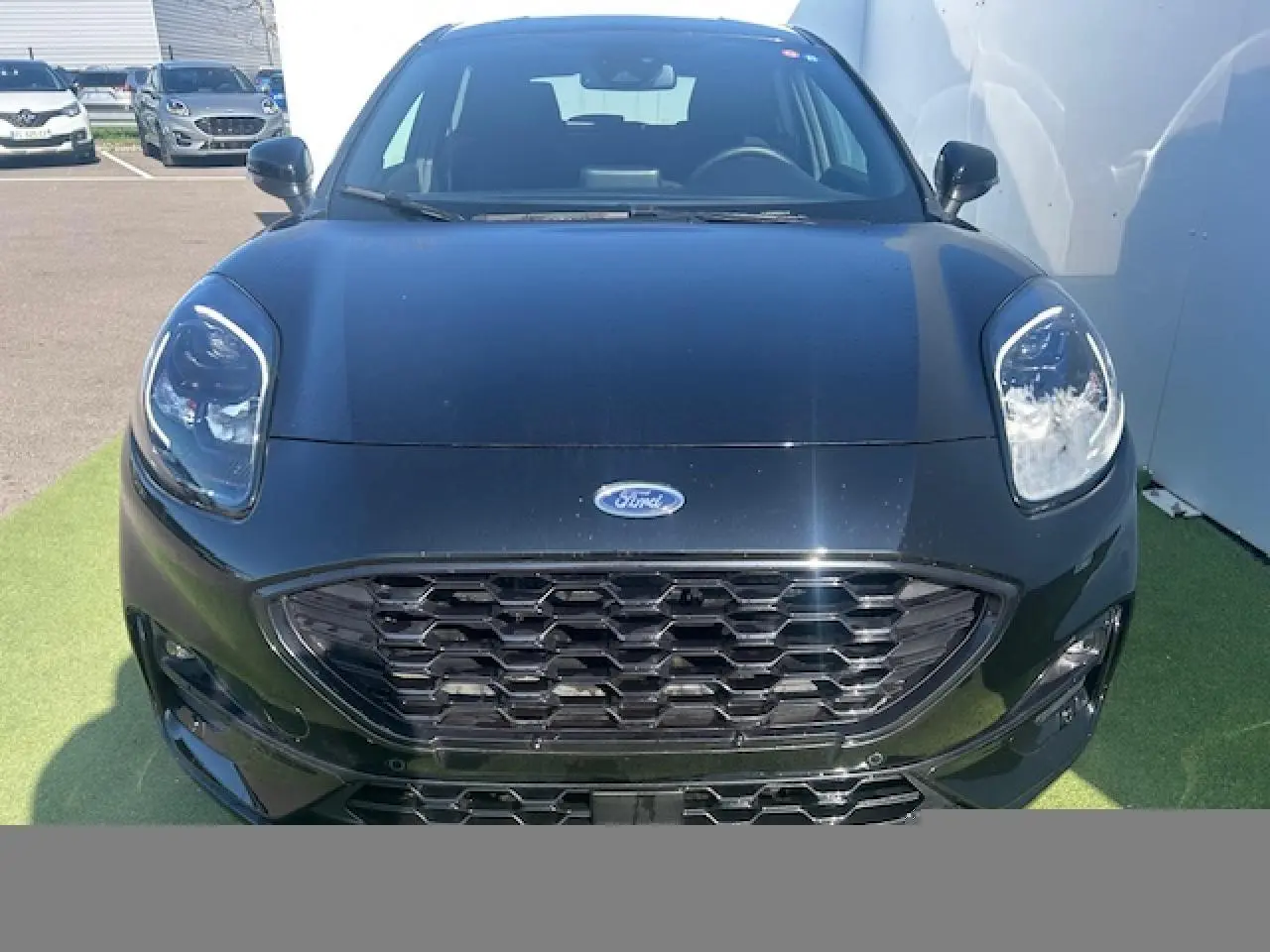 Vue avant rapprochée d'une Ford Puma noire Agate avec calandre hexagonale et phares LED distinctifs.