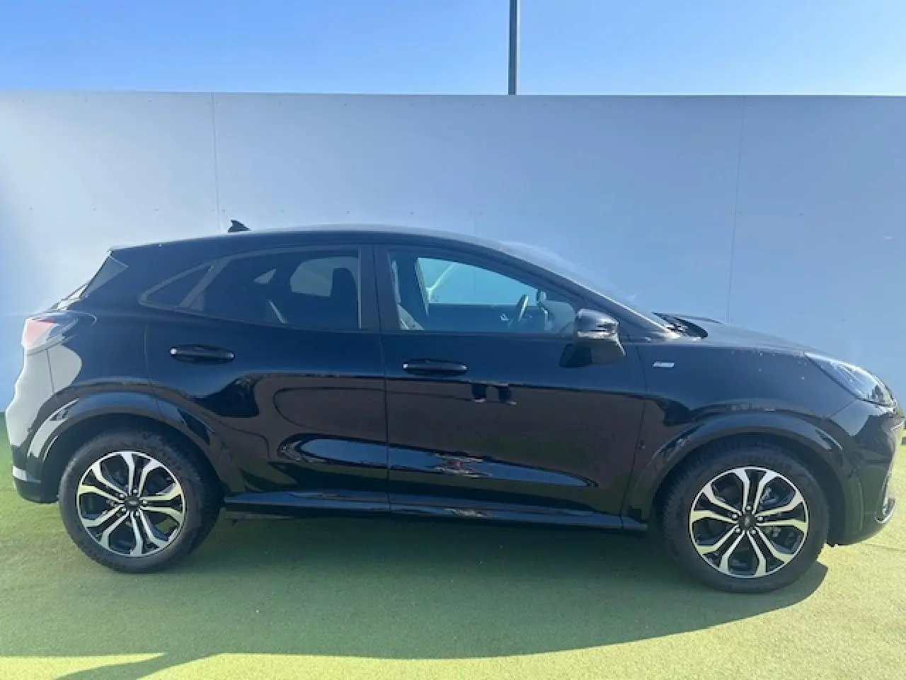 Profil côté gauche d'un Ford Puma noir Agate 2023 avec jantes alliage et badges ST-Line visibles.