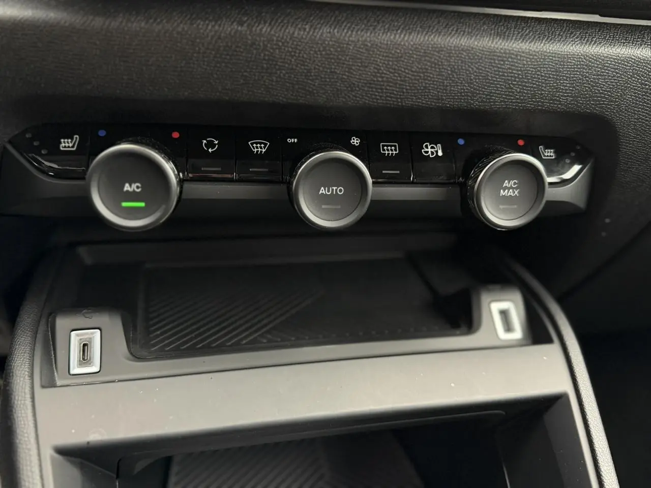 Détail de la console centrale noire avec commandes de climatisation automatique et ports USB du Citroën C4 2024.