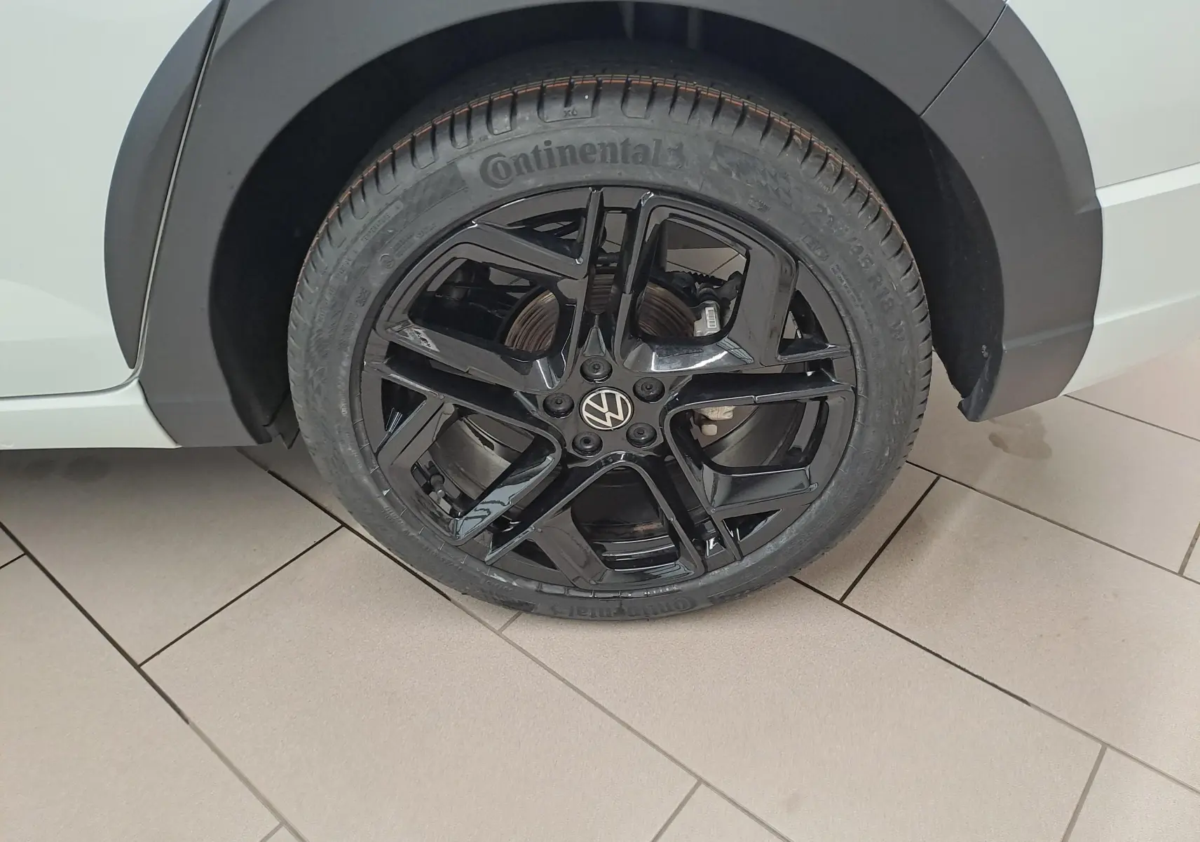 Gros plan sur la jante noire en alliage léger 18'' York du Volkswagen Taigo blanc pur, côté arrière droit.