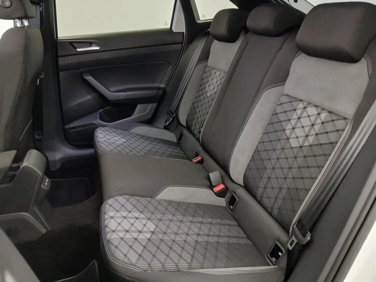Vue intérieure côté droit des sièges arrière du Volkswagen Taigo 2025 avec sellerie tissu gris à motifs géométriques.