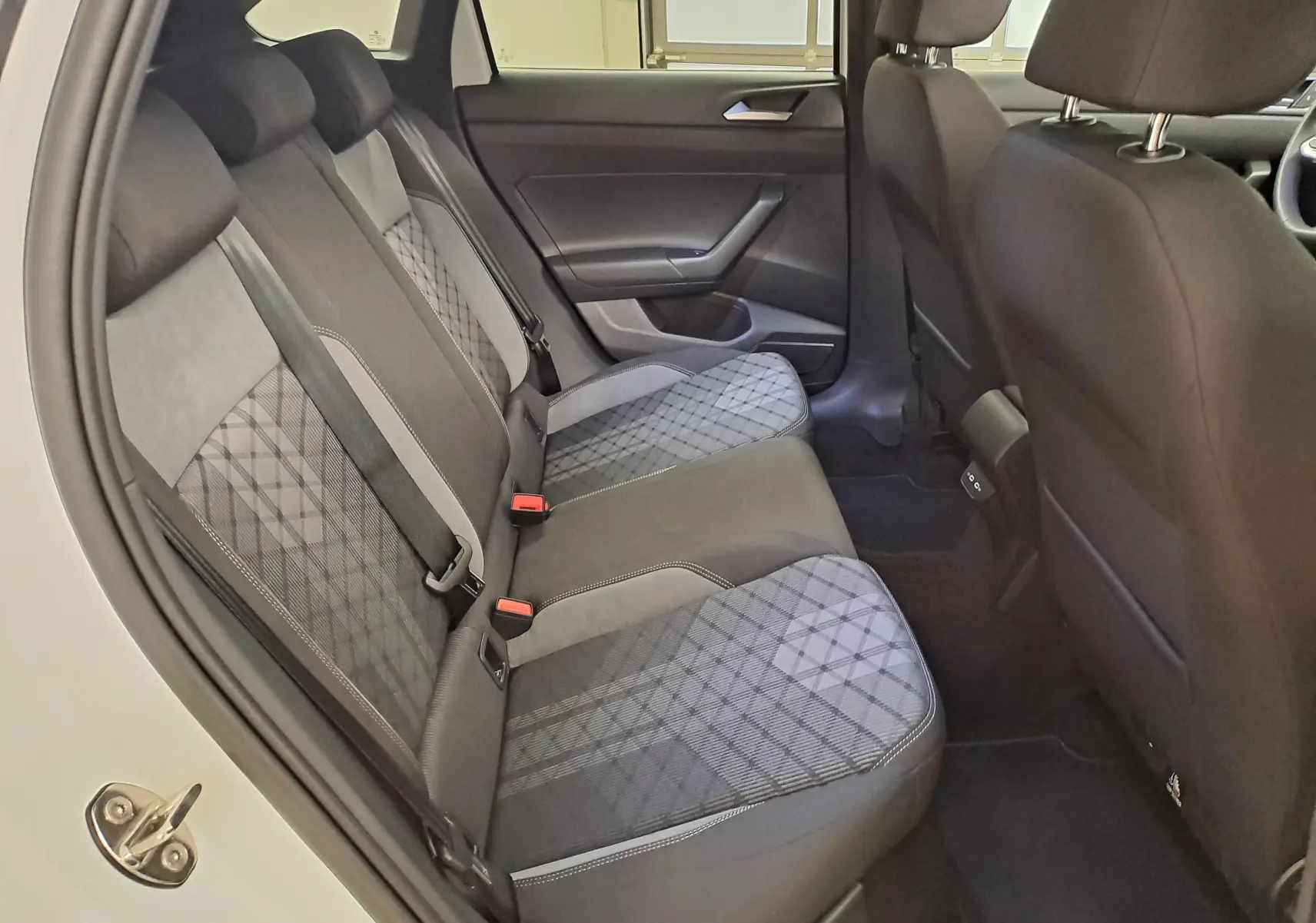 Vue intérieure côté droit des sièges arrière en tissu gris à motifs géométriques du Volkswagen Taigo 2025.