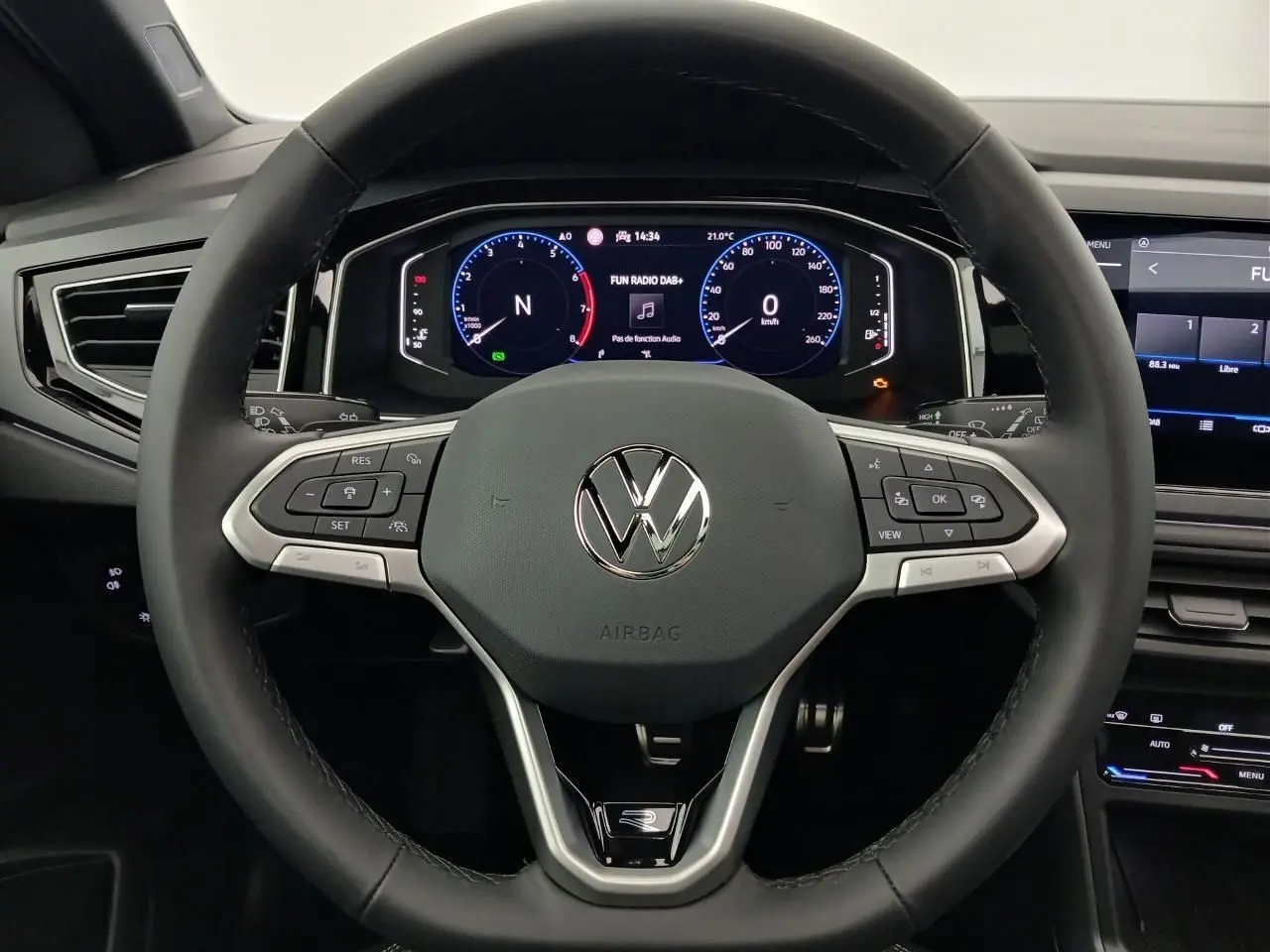 Vue rapprochée du volant cuir multifonctions Volkswagen Taigo 2025 avec tableau de bord digital et commandes intégrées.