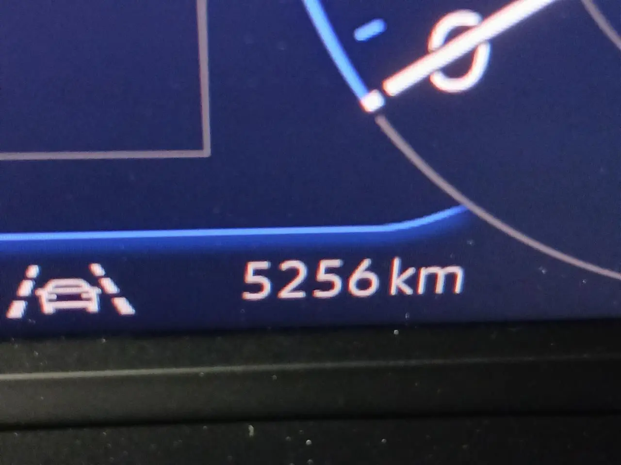 Vue rapprochée du tableau de bord numérique affichant 5256 km et l'icône d'assistance au maintien de voie.