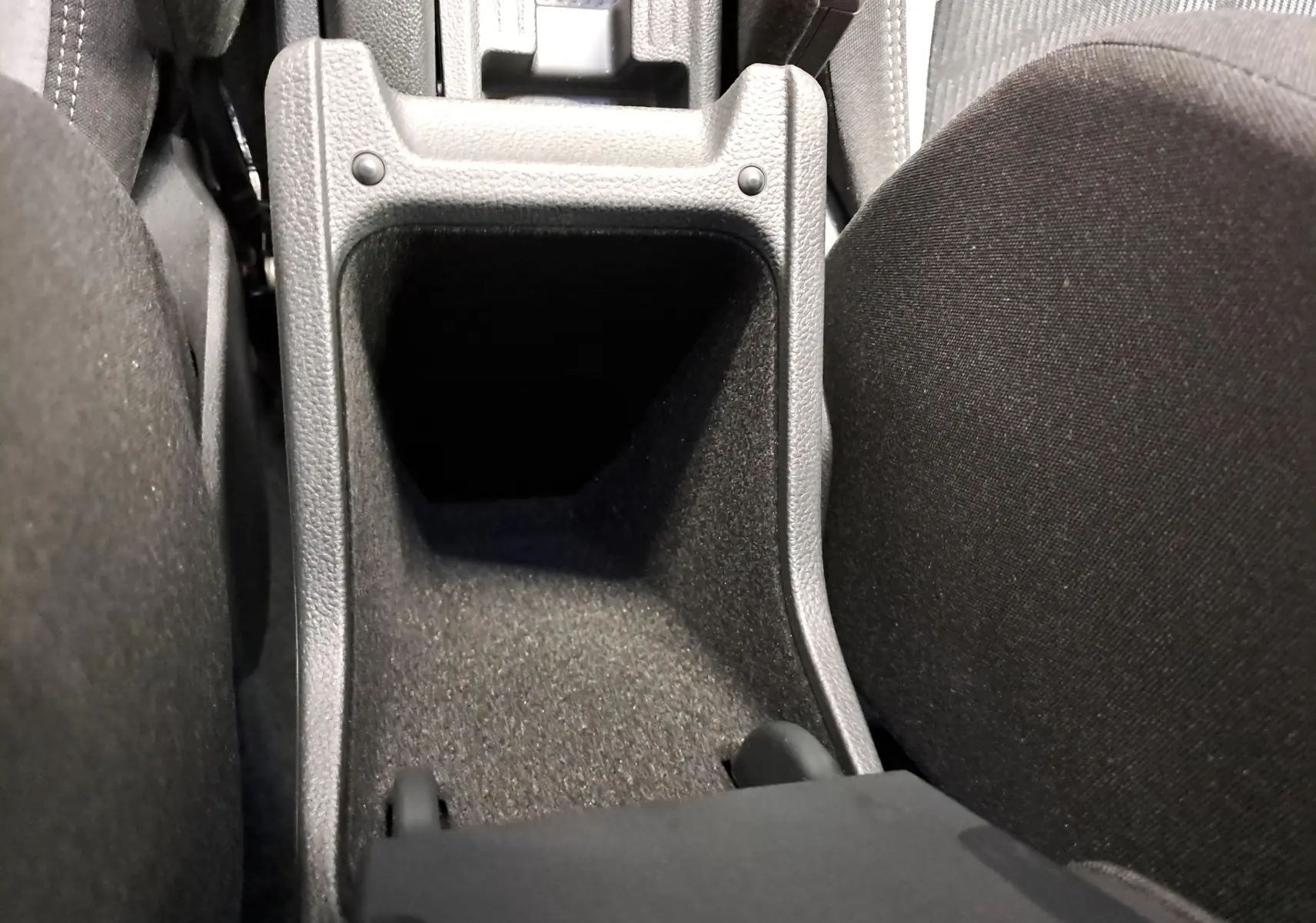 Vue rapprochée de la console centrale noire entre les sièges avant du Volkswagen Taigo 1.5 TSI R-Line Edition.