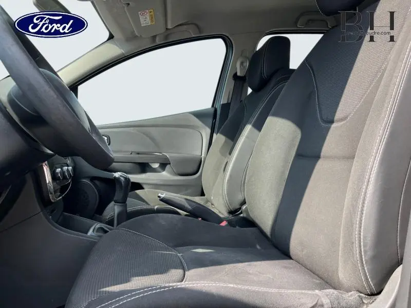 Vue intérieure côté conducteur montrant les sièges tissu noirs et la console centrale d'une Renault Clio gris Cassiopée.