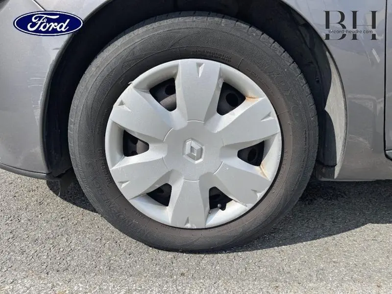 Gros plan sur la roue avant droite gris Cassiopée d’une Renault Clio 2013 avec enjoliveur marqué du logo Renault.