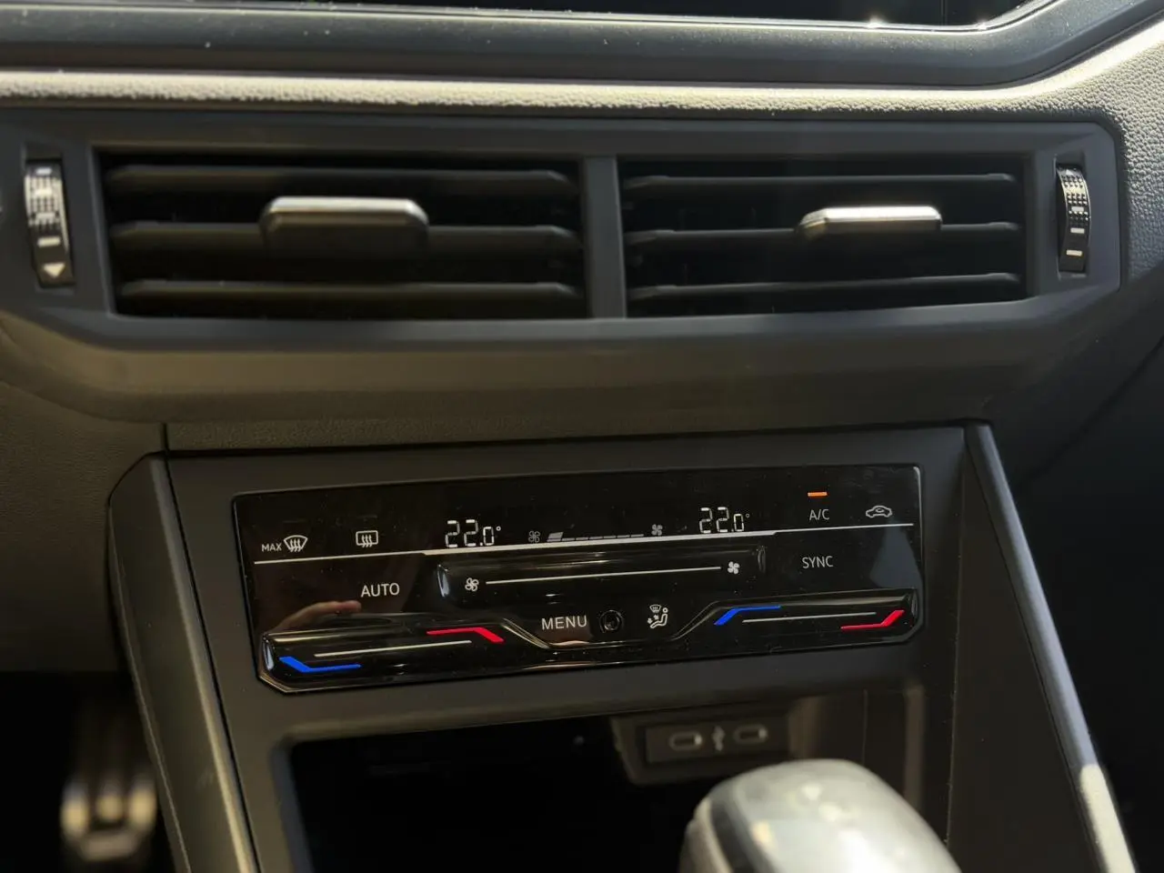 Détail de la console centrale avec climatisation automatique bi-zone et commandes tactiles dans un Volkswagen Taigo argent Reflex.