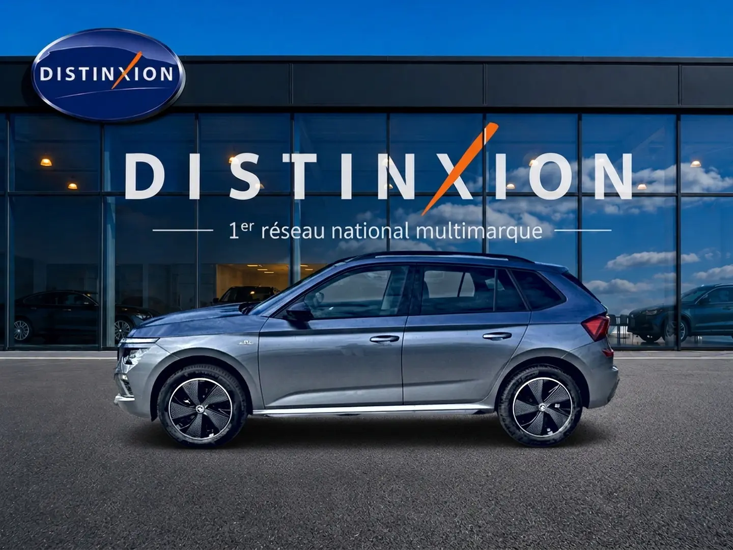 Vue latérale droite d'un Skoda Kamiq gris graphite 2026 avec jantes alu noires et toit panoramique en verre.